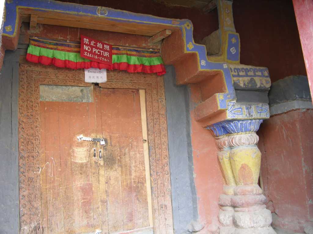 Tibet Guge 03 Tholing 06 White Temple Entrance Door The entry to Tholing's White Temple is marked by two interesting deodar (cedar) columns originating in India, probably 500 years old. Along the left and right walls of Tholings White Temple are murals depicting a series of male and female bodhisattvas. Over three metres high, some of them are represented within a formal aureole, others within a celestial palace, and yet others in a natural landscape setting of mountains and forests.